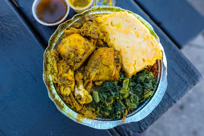 Curry Chicken on Peas and Rice with Macaroni Pie and Bhaggee ($10.50)